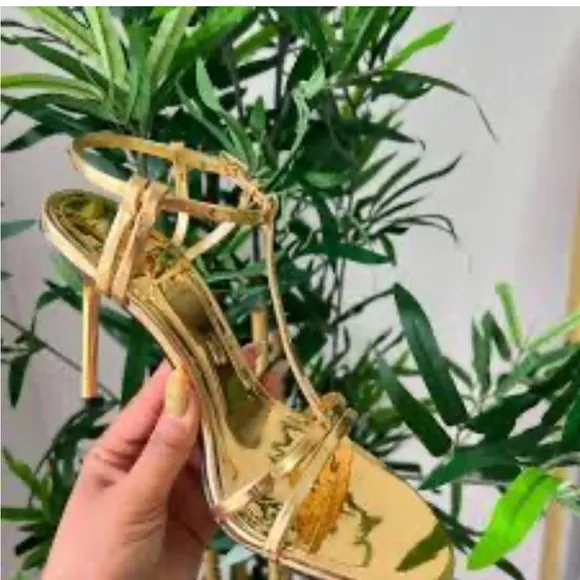 Metallic high-heel with ankle straps. Elegant Gold Stiletto Sandals.